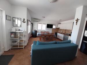 ストンにあるKuća za odmor >Maro<の青いソファとキッチンのあるリビングルーム