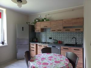 a kitchen with a table and a kitchen with a refrigerator at U Wioli in Lubawka