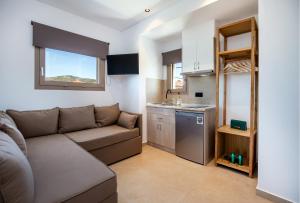 a living room with a couch and a kitchen at Calma Living in Potos
