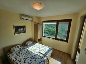 ein Schlafzimmer mit einem Bett und einem großen Fenster in der Unterkunft Apartments Vista in Baltschik