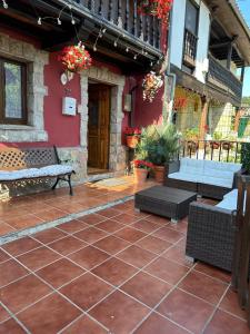 a patio with a bench and a red building at Casa rural in Mestas del Con +26 photos