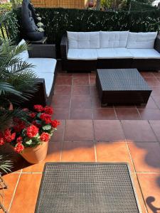 a patio with a couch and tables and flowers at Casa rural in Mestas del Con