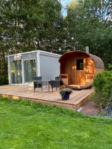 a wooden deck with a sauna in a backyard at Pauna Puhkemaja in Tori