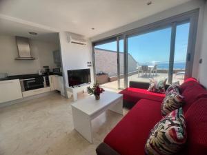 a living room with a red couch and a large window at El Ático in Alicante