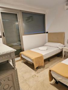 a bedroom with two beds and a window at El Ático in Alicante