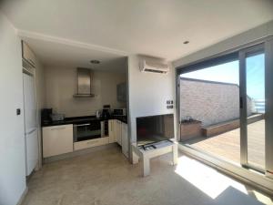 a kitchen with a large sliding glass door with a balcony at El Ático in Alicante +4 photos