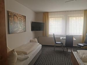 ein Hotelzimmer mit Bett, Tisch und Stühlen in der Unterkunft Hotel Sonne in Wolfach