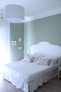 a bedroom with a large white bed with two pillows at B&B Nannalia in Marina di Carrara