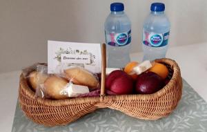 a basket of fruit with two bottles of water at Villa Benvengudo in Villeneuve-lès-Avignon