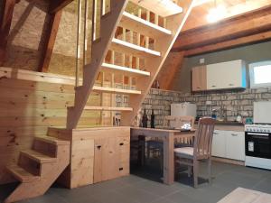 a kitchen with a wooden table and a wooden staircase at Planinski Raj in Njegovuđa