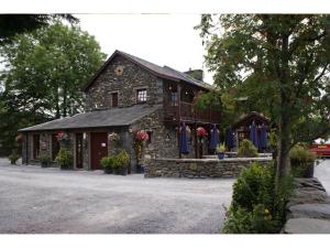 ein Steingebäude mit Blumen davor in der Unterkunft The Watermill Inn & Brewery in Windermere