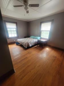 a bedroom with a bed with two windows and a ceiling at Cozy Apartment in Historic East Knoxville in Knoxville