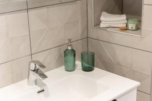 Un baño con una botella de jabón en el lavabo. en L'escale Parisienne - METRO 3 min, Proche JO, Direct au Louvre,Galeries Lafayette, Opéra,, en Aubervilliers 7 fotos más