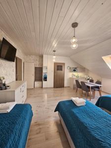 a large room with two beds and a dining room at Pokoje Gościnne Pod Lipami in Kudowa-Zdrój