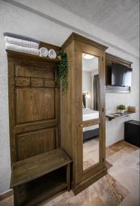 a wooden cabinet with a mirror in a room at Selora Vama Veche in Vama Veche