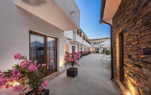 a corridor of a building with flowers on the sidewalk at Selora Vama Veche in Vama Veche