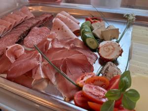 ein Tablett mit Fleisch und anderem Fleisch und Gemüse in der Unterkunft Hotel Sonne in Wolfach