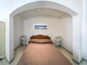 een bed in een witte kamer met twee tafels bij Appartamento Panoramic in Lerici