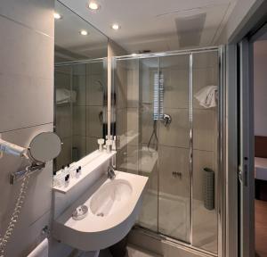 un bagno con lavandino e doccia di Hotel Daniel & Ristorante Cocchi a Parma