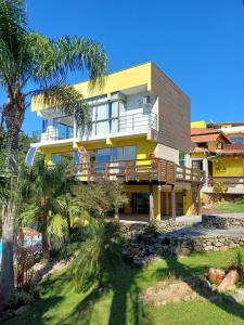 an exterior view of a house with palm trees at Suíte Amazônia in Bombinhas