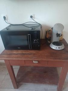 a microwave sitting on top of a wooden table at maison en ville au calme in Fleurance