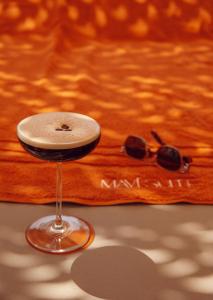 a glass of wine and a pair of sunglasses on a table at Mavi Suite Turkbuku in Golturkbuku