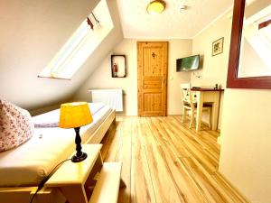 a room with a bed and a table with a lamp at Land & Leben Pension in Chemnitz