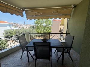 Ein Tisch und Stühle auf einem Balkon mit Aussicht in der Unterkunft VALENTINA Luxury apartment in Kavala