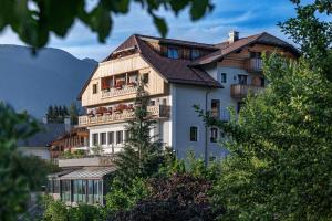 Hotel Post - OlangCard included في فالداورا: مبنى أبيض كبير مع شرفات على تلة