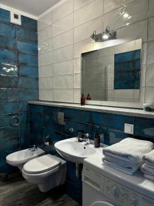 Un baño con dos lavabos, un inodoro y un espejo. en Modern Studio in Old Town, en Poznan
