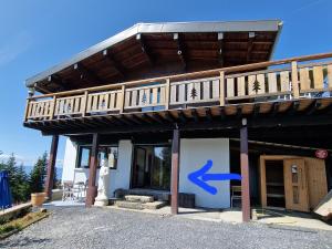a house with a deck with a blue arrow on it at Appartement Les Montagnes de Saxel in Saxel +16 photos