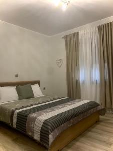 a bedroom with a bed and a window with curtains at Coastal vista 2 in Neos Panteleimonas