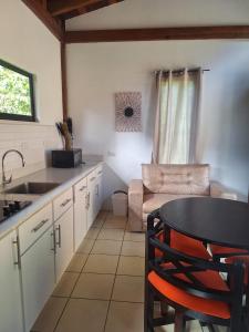 a kitchen with a sink and a table and a couch at La cabaña del Dulce in San Rafael Norte +5 photos