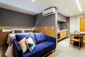 um quarto com uma cama e um sofá azul em Apartamento em Maceio - Loft 1208 em Maceió