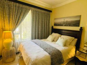 プレトリアにあるTG Villa Menlynのベッドと大きな窓のある寝室 +21枚の写真