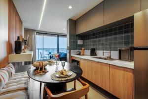 uma cozinha com uma mesa e um sofá em Apartamento em Maceio - Loft 1208 em Maceió