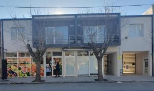 a woman standing in front of a building at Heart Depto 1 Viedma Centro Confortable y Optima Ubicación in Viedma