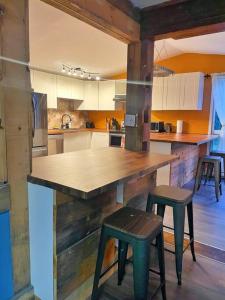 une cuisine avec un comptoir en bois et deux tabourets dans l'établissement Escape to Corry Lake Cottage, à Chalk River