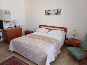 una camera da letto con un letto e una sedia di Casa Arcamaria - Appartamento ad Avetrana