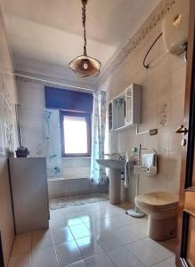 bagno con lavandino, servizi igienici e finestra. di Casa Arcamaria - Appartamento ad Avetrana