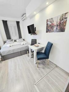 a bedroom with a bed and a table and a tv at Cube Gray in Mostar