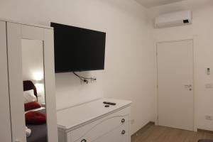 a room with a tv on a white wall at Blue Home in Pero