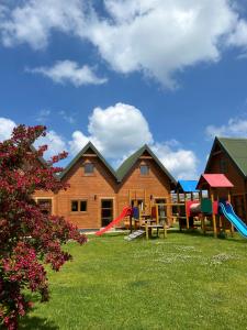 a house with a playground in the yard at Domki Kaja in Rewal