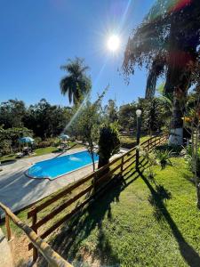 a wooden fence next to a swimming pool at Chácara Recanto da família in Jacutinga