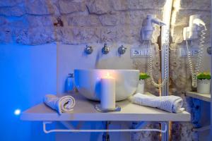 a candle sitting on a counter with a sink at Alloggio Turistico Suite Nino in Ceglie Messapica