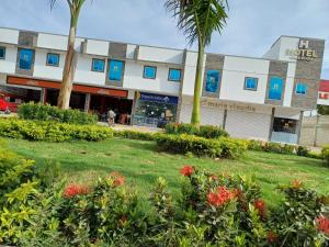 a building with trees and flowers in front of it at Hotel Mall plaza in Santa Marta