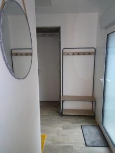 a mirror on the wall of a room with a bench at Chez alexia et cédric in Joué-sur-Erdre
