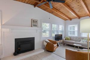 Una sala de estar con chimenea y un sofá. en Charming 1960s Cottage, 5 Min Walk to Beach and Shops, en Oak Island