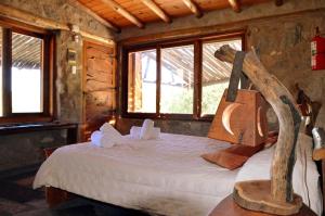 a bedroom with a bed in a log cabin at Cabañas Los Arroyitos in Potrero de los Funes