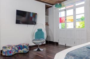 a room with a chair and a tv and a bed at Placita Vieja Hotel Boutique Spa in Santa Marta